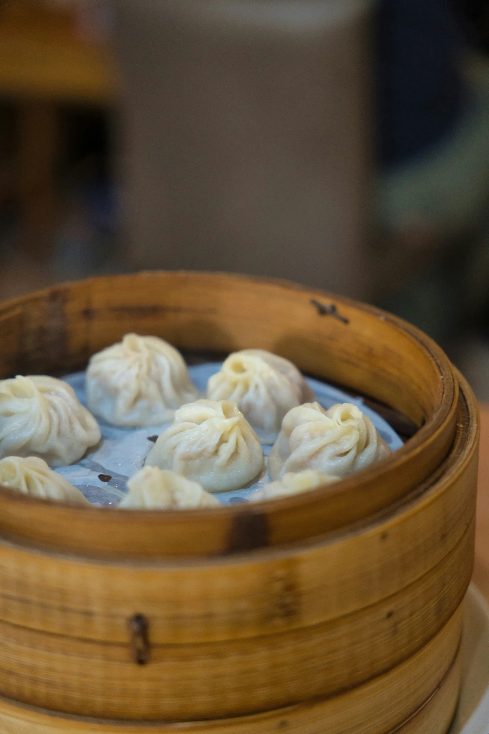 Pleated soup dumplings steamed in a bamboo basket